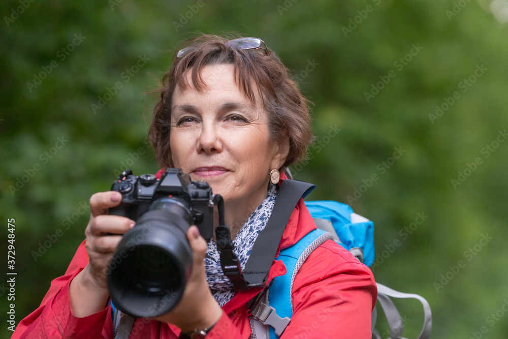 Close-up portrait of a senior birdwatcer woman with camera. Close-up portrait of a senior birdwatcer woman with camera.