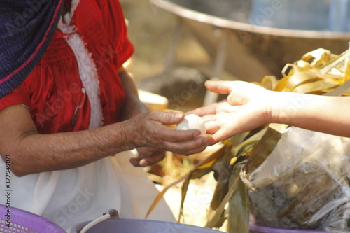 hands of indigenous woman with dumpling to make Mexican tamales called corundas