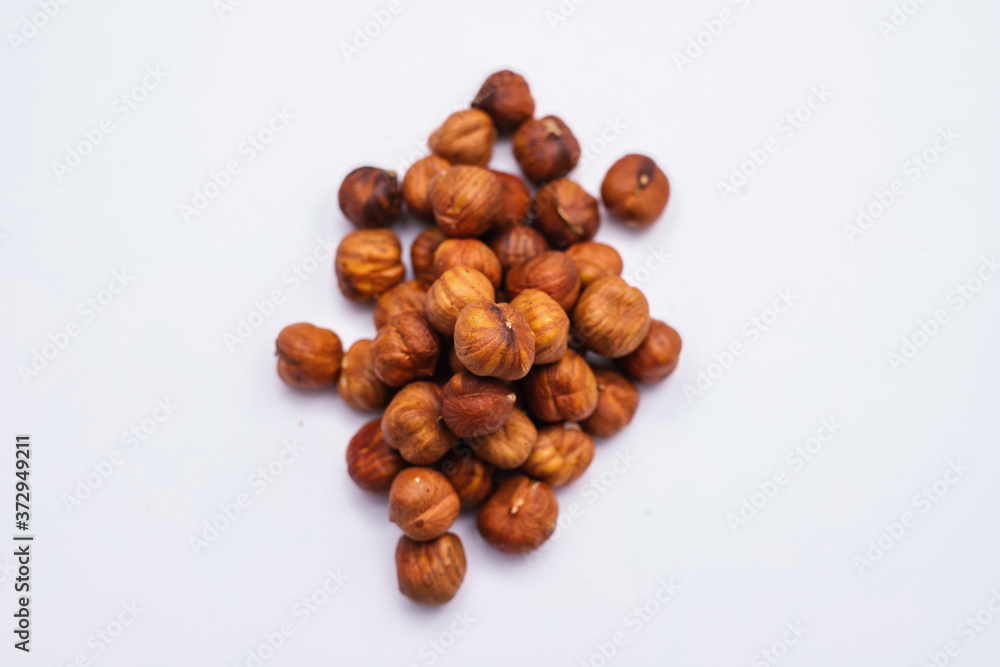 Whole hazelnut kernels lie on a white background. The autumn harvest. Whole hazelnut kernels lie on a white background. The autumn harvest.