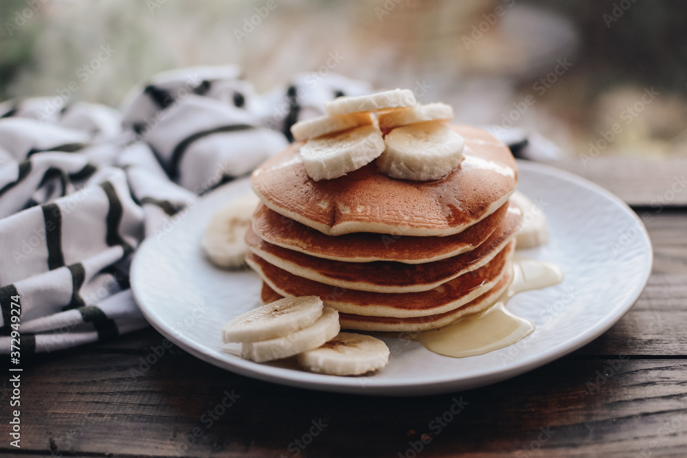 Delicious pancakes topped with banana and honey. Homemade classic american pancakes. Breakfast in the morning. Delicious pancakes topped with banana and honey. Homemade classic american pancakes. Breakfast in the morning.