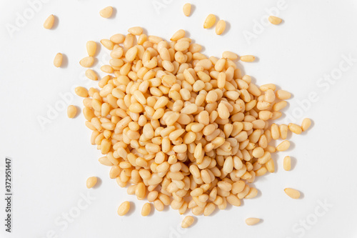 Peeled Pine Nuts. Unshelled kernels. A bunch of nuts lies on a white background.