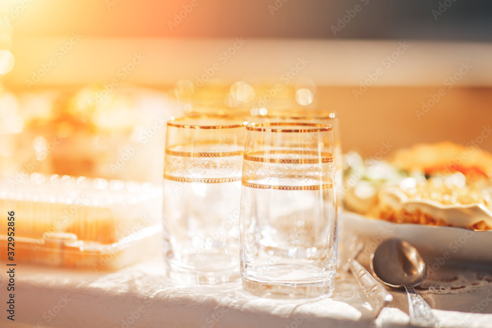 Long table covered with a tablecloth on which there is a lot of food, food in plates Long table covered with a tablecloth on which there is a lot of food, food in plates
