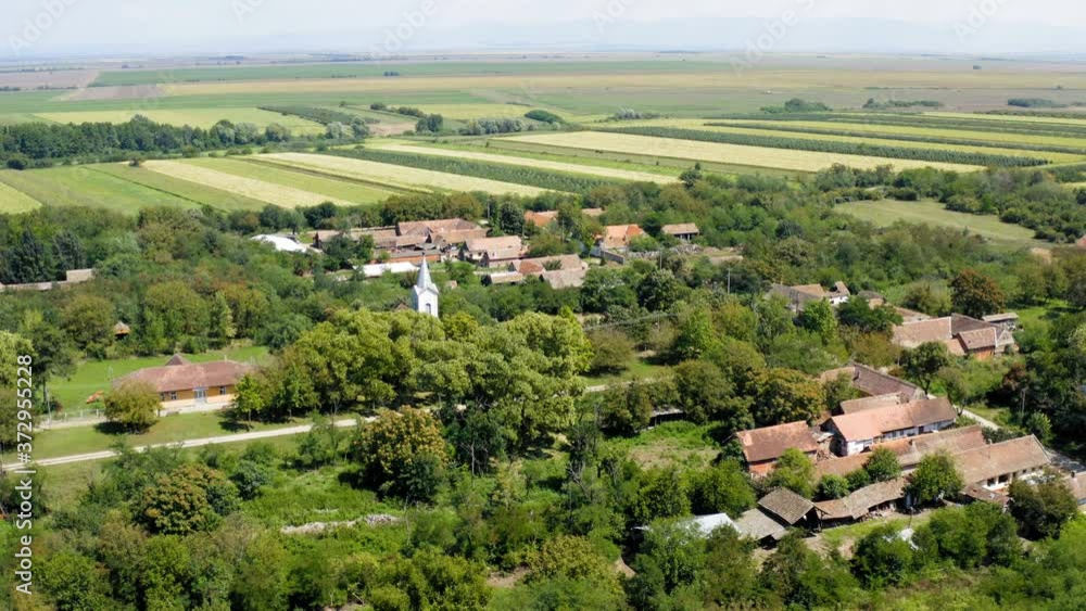 Flight with a drone over small village surrounded by wheat fields on bright sunny day Flight with a drone over small village surrounded by wheat fields on bright sunny day