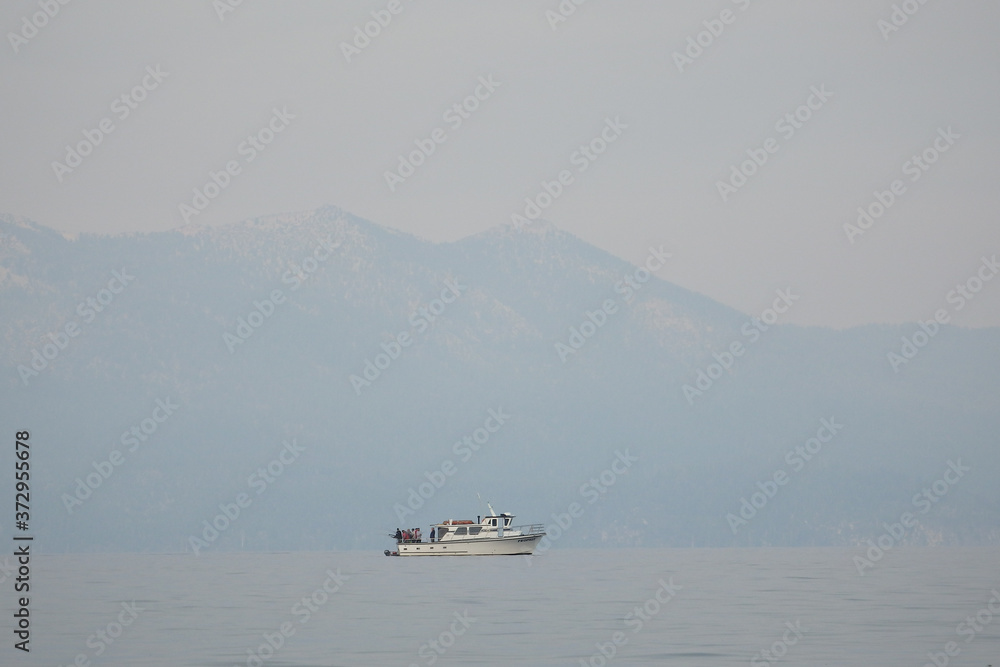 Smokey Skies Over Lake Tahoe with a Fishing Boat in the Foreground and Surrounding Western Sierras from Nevada Beach Nevada in from Wildfires of August 2020