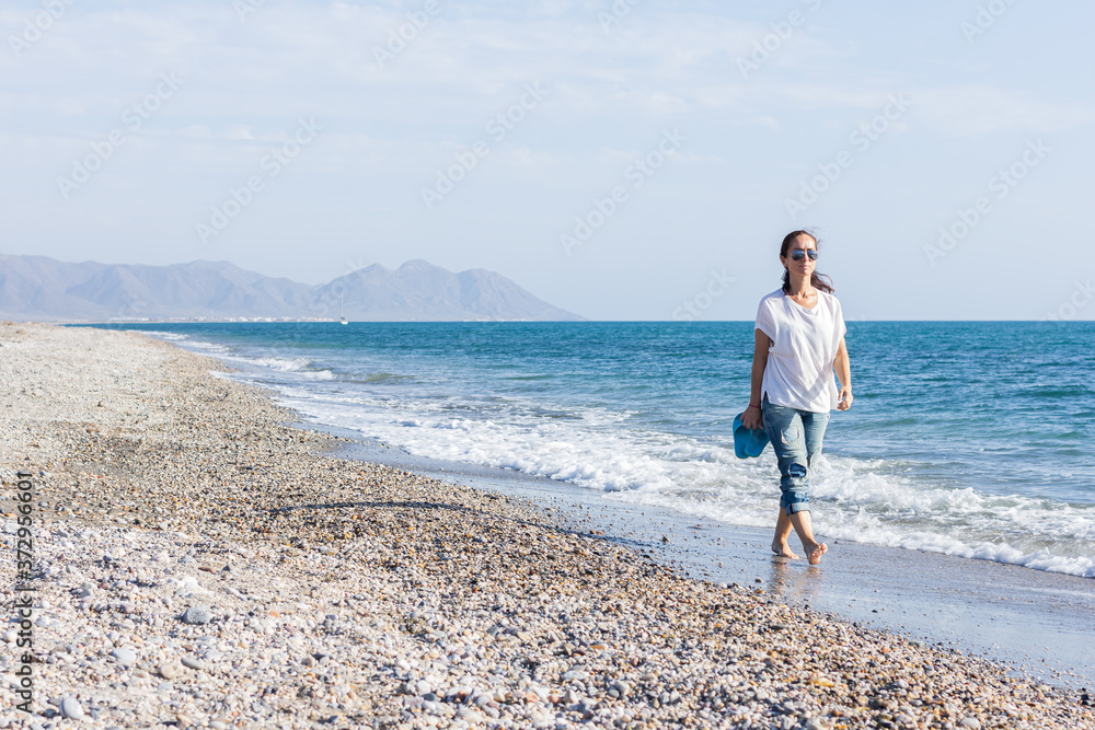 Woman taking a relaxing walk on the beach.