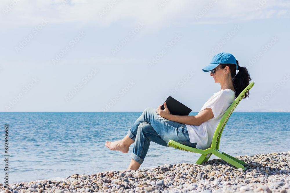 Woman reading a book on the beach.