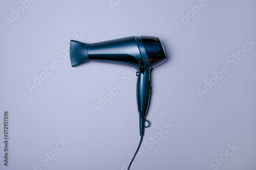 Black hair dryer on gray background, top view