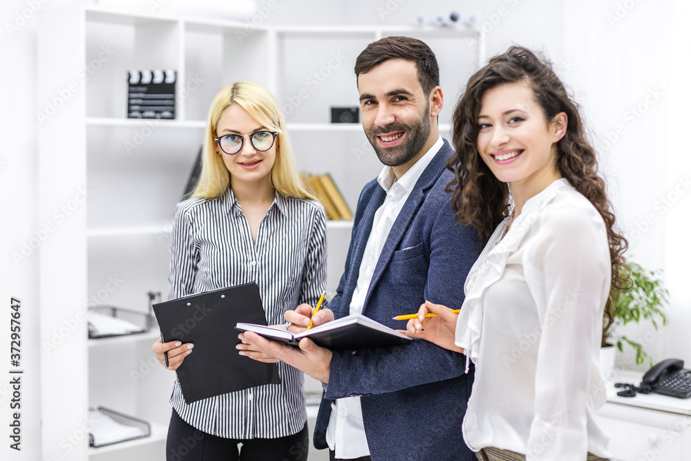 Fototapeta premium Portrait of colleagues employees cooperating in office talking working together at workplace.