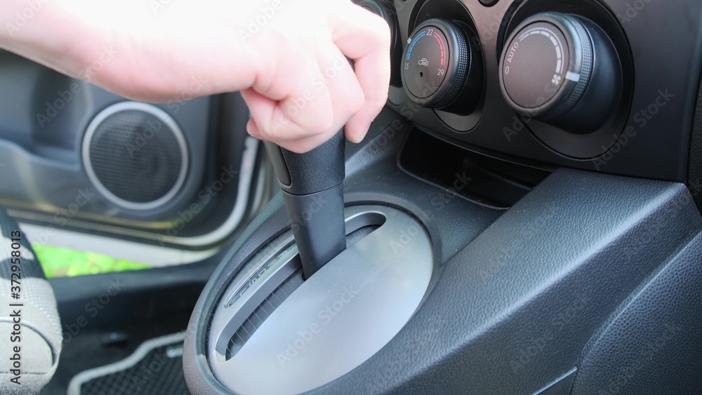 Close-up of male hands switching automatic gearbox in car, driver Close-up of male hands switching automatic gearbox in car, driver