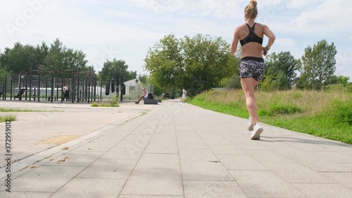 Female athlete's feet running at the park. Fitness woman jogging outdoors.