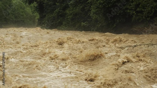 Disaster flood deluge and water flow after rainfall. Weather cataclysm. Raging river with dirty water. Natural disasters, extreme weather.