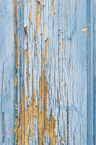 Vertical photo of the detail of a vintage blue worn wood door