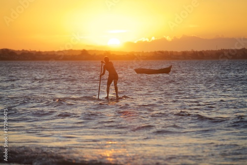 woman paddle board in Rio de Janeiro at sunset