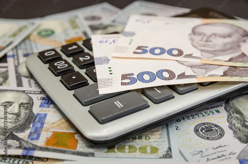 Ukrainian 500 hryvnia with a calculator and dollars. Financial concept. Ukrainian 500 hryvnia with a calculator and dollars. Financial concept.
