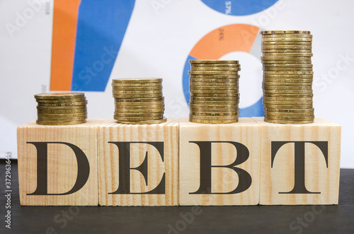 Wallpaper Mural A symbol of increasing debt. the word "debt" and the stacks of coins are arranged in order of growth. Business graph in the background. Torontodigital.ca