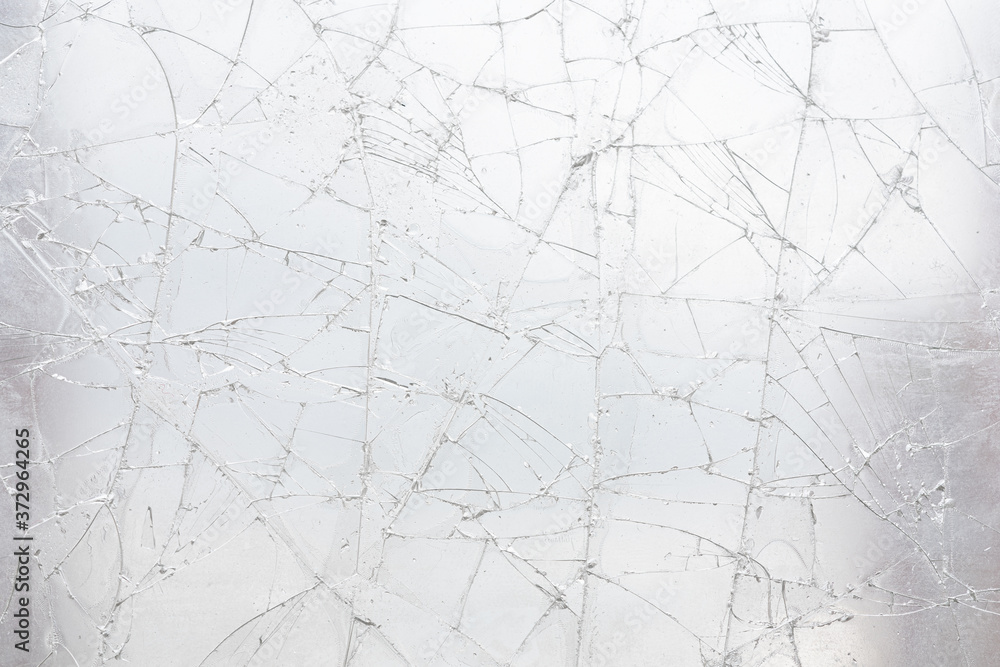 Fototapeta premium White cracked glass texture background. Texture broken glass window with cracks. Broken screen.