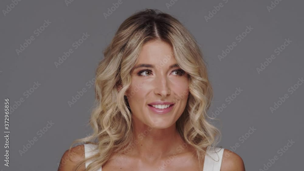 Studio portrait of young and beautiful blond woman over grey background. Studio portrait of young and beautiful blond woman over grey background.