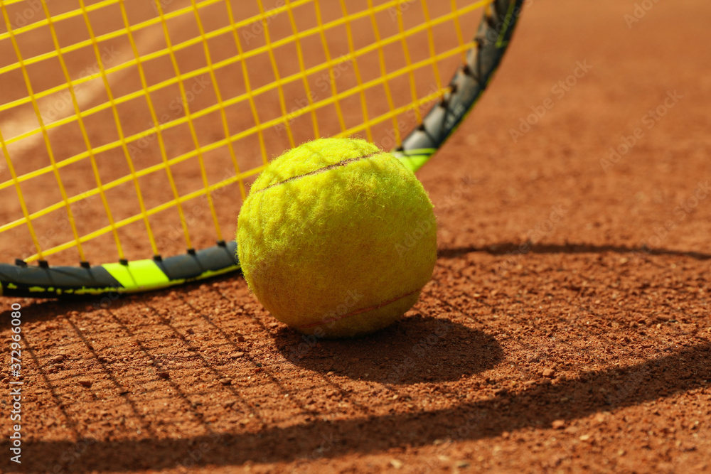 Tennis racquet and tennis ball on clay court