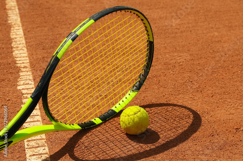 Tennis racquet and tennis ball on clay court © Atlas