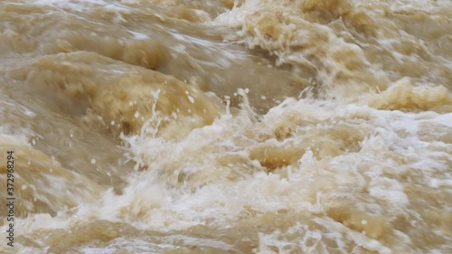 Crowded river overflows its banks. Raging river with dirty water. Natural disasters, extreme weather. Disaster flood deluge and water flow after rainfall.