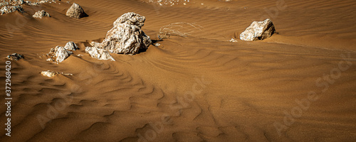 The sand changes shape due to the wind to form sand ripples and jagged lines