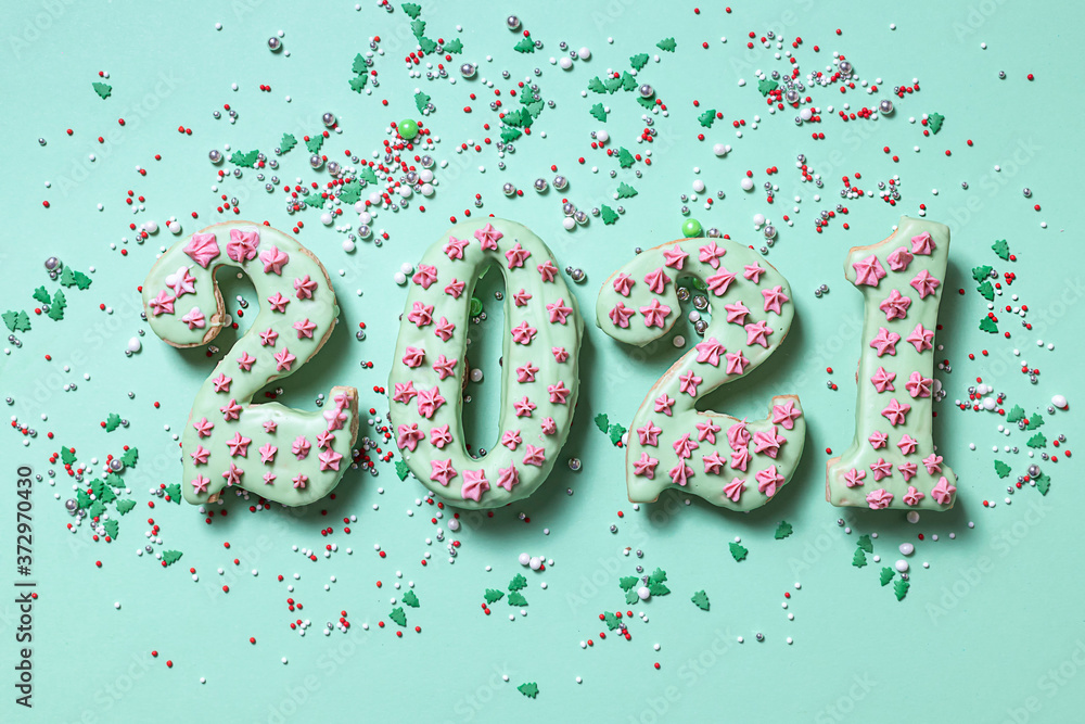 Cookies, gingerbread in the form of New Year's numbers 2021 on a green background. Happy New Year 2021 and Merry Christmas. Multi-colored sugar topping for dough. Cookies, gingerbread in the form of New Year's numbers 2021 on a green background. Happy New Year 2021 and Merry Christmas. Multi-colored sugar topping for dough.