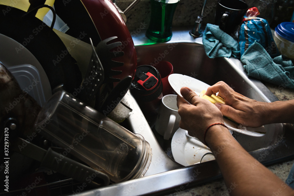 Obraz premium Washing dishes because in quarantine, dirty dishes do not stop.
