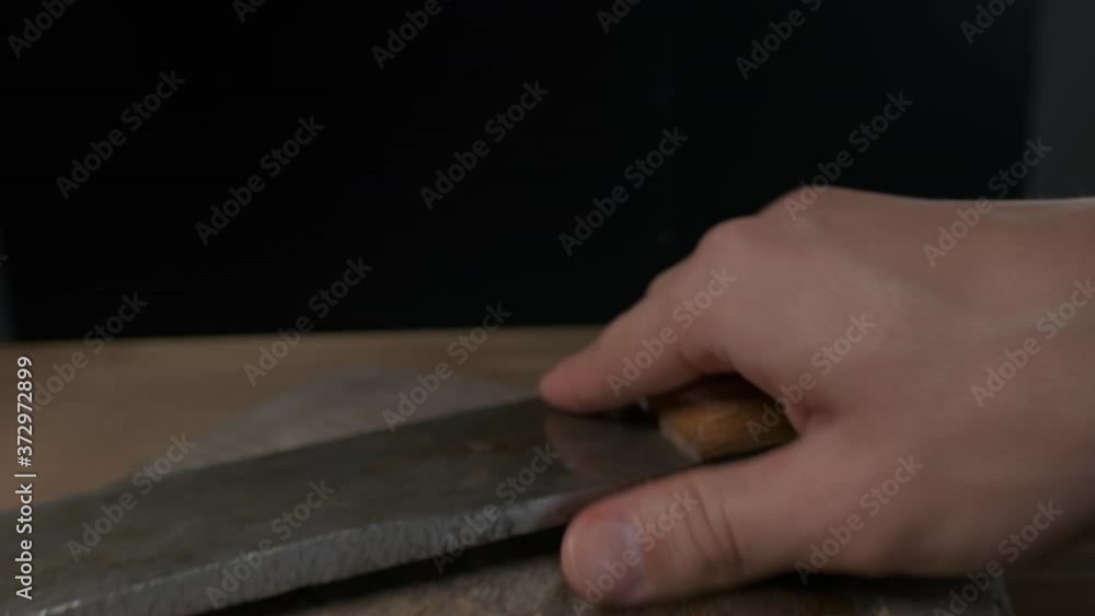 the chef prepares to cut a whole grilled chicken with a large knife, slow motion the chef prepares to cut a whole grilled chicken with a large knife, slow motion