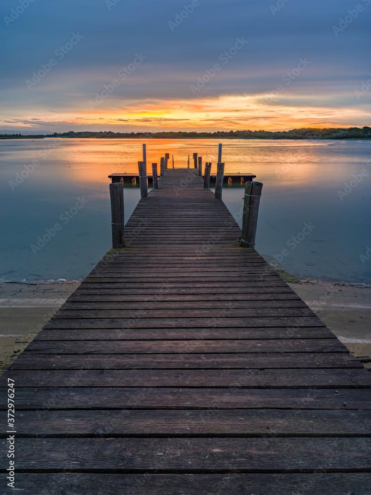 Lagoon landscape at dawn with wooden jetty