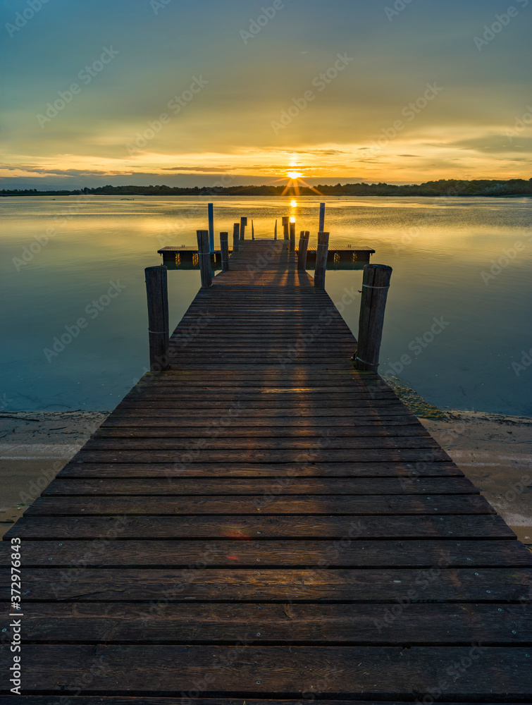 Lagoon landscape at dawn with wooden jetty Lagoon landscape at dawn with wooden jetty