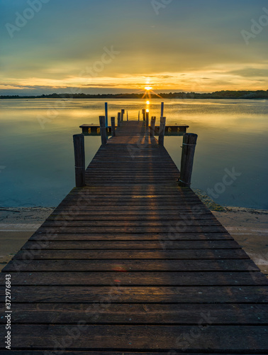 Lagoon landscape at dawn with wooden jetty