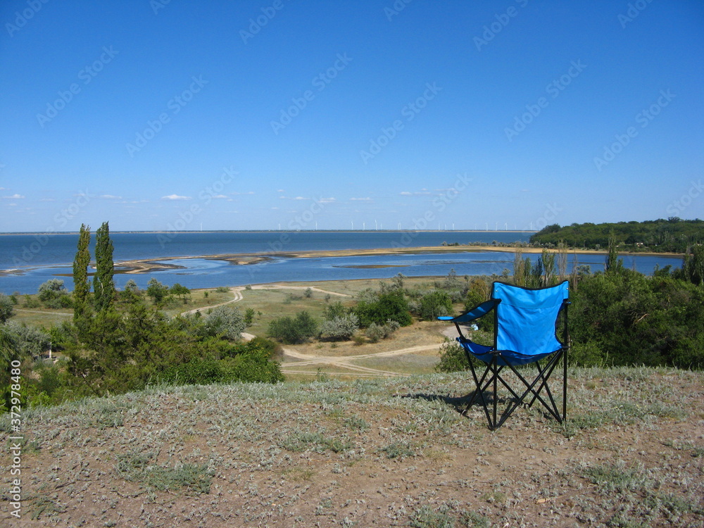 photo with a blue chair against a background of beautiful nature implying relaxation