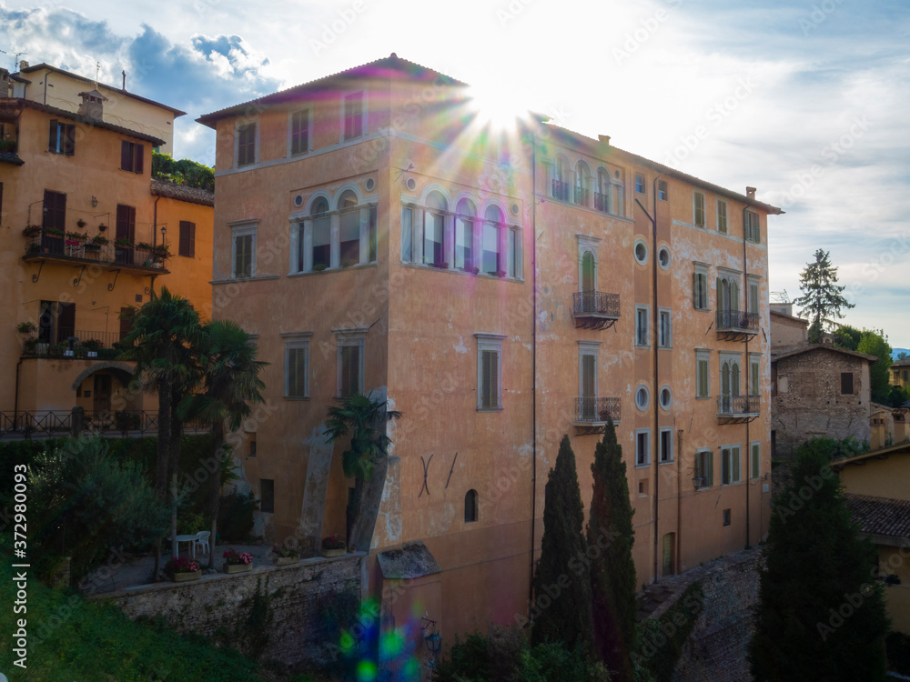Reflejos y flares, rayos de sol sobre un edificio en el casco antiguo de Spoleto, Italia, verano de 2019.