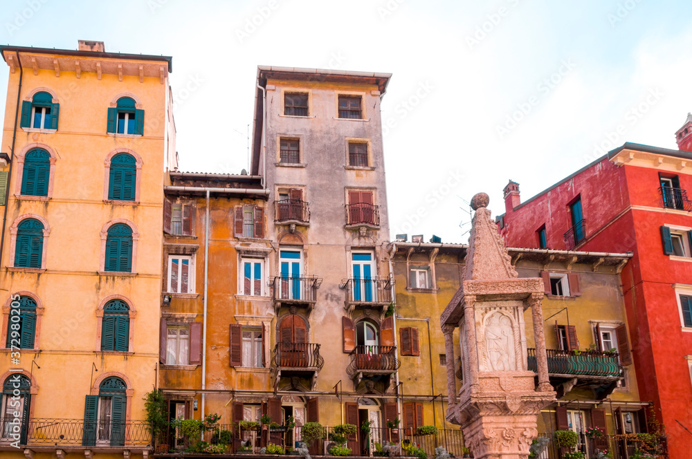 Colorful facades of old houses with balconies on Piazza delle Erbe in old city Verona, Northern Italy.