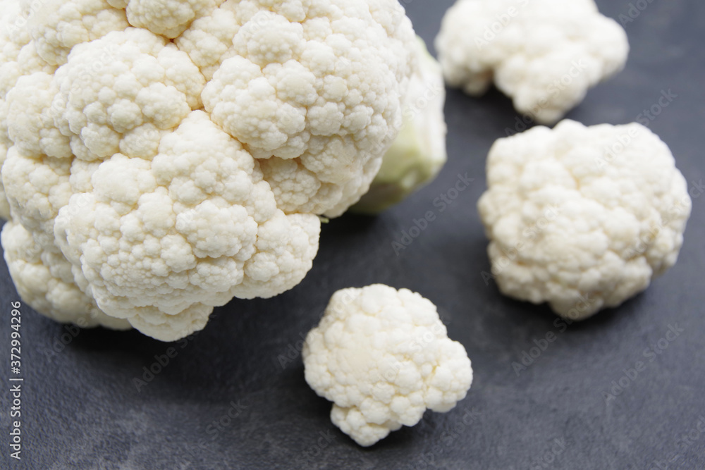 Cauliflower vegetable head on black background. Fresh raw vegan food Cauliflower vegetable head on black background. Fresh raw vegan food