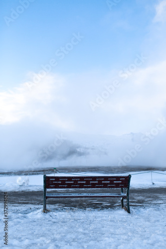 Bench for rest overlooking a cloud of steam in winter © Kate