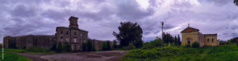 Old haunted stone mental hospital near of a abandoned church in the field Old haunted stone mental hospital near of a abandoned church in the field