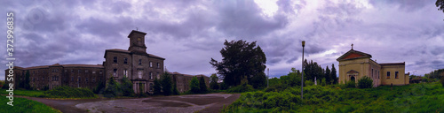 Photography Old haunted stone mental hospital near of a abandoned church in the field