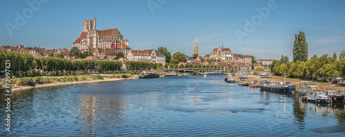 Beautiful shot of the Auxerre Cathedral near the Yonne river on a sunny afternoon in France photo