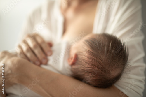 Newborn baby nursing breastfeeding from mother 
