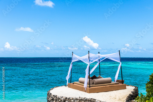Fototapeta Naklejka Na Ścianę i Meble -  Beautiful view of sun bath bed in Maldives with a cloudy sky background
