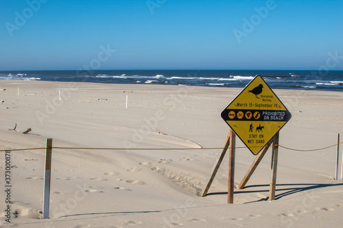 Yellow warning sign for habitat protection of the Snowy Plover along Oregon Coast in Florence, Oregon.