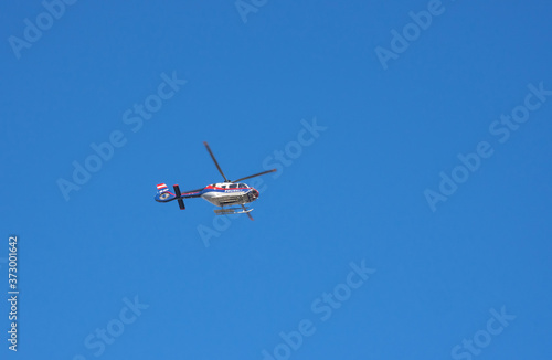 Austrian federal police helicopter flying, blue sky in the background