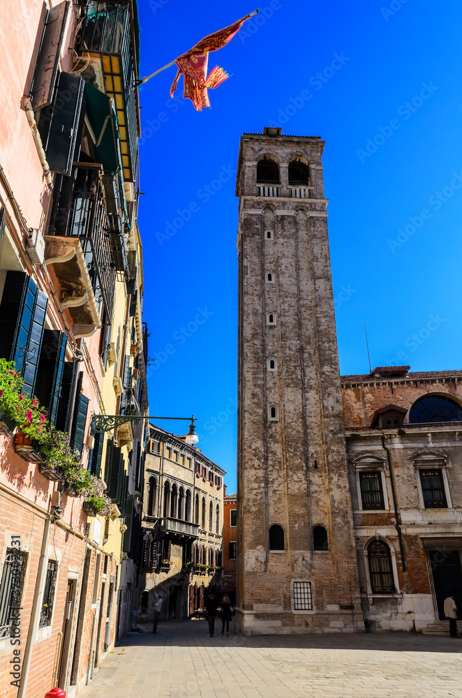 The old streets of Venice, the bell tower and the ancient flag of the Venetian Republic. Venice. Italy