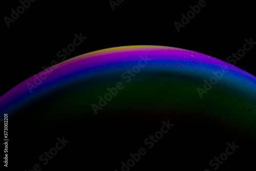 Detail of light in a soap bubble, allusion to the micro universe in a studio with a black background, use of natural and artificial light.