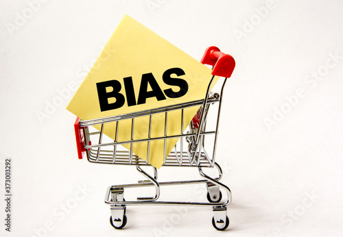Shopping cart and text bias on white paper note list. Shopping list, business concept on white background.