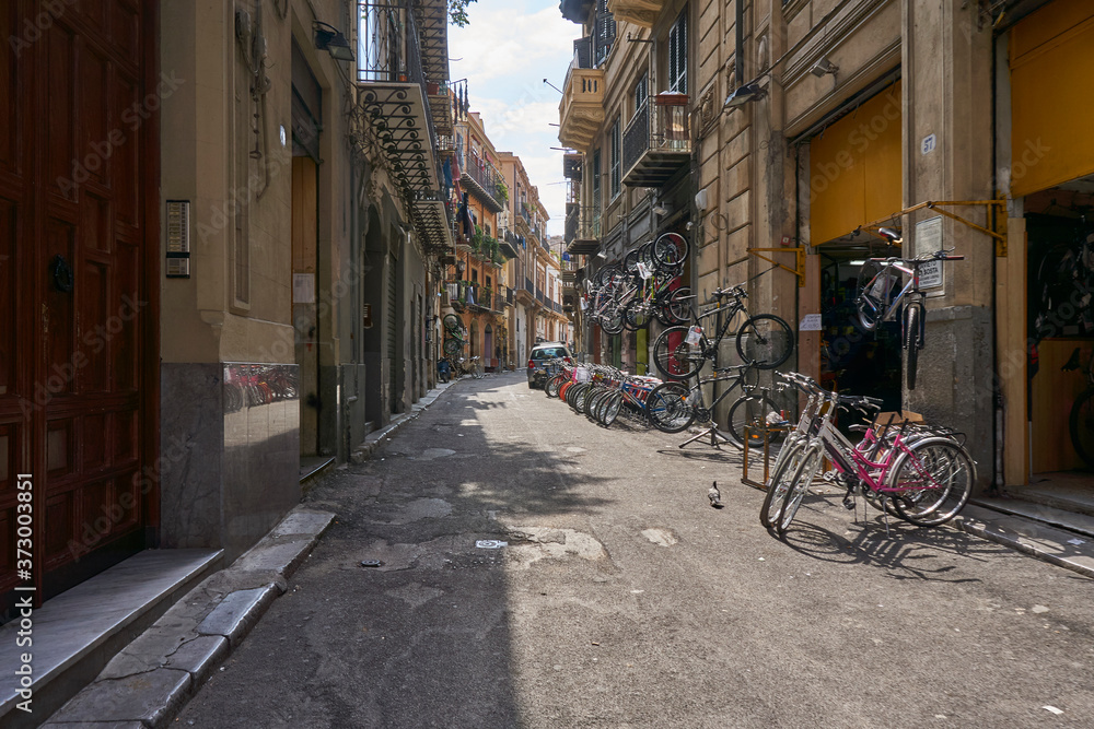 Fototapeta Boczna ulica w Palermo Sycylia ze sklepem rowerowym i typowym życiem