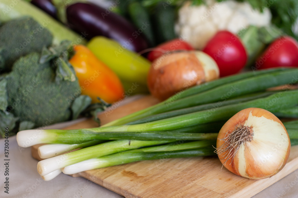 delicious fresh green and onions on a beautiful background of blurry vegetables delicious fresh green and onions on a beautiful background of blurry vegetables