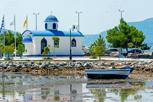 Fishing boats and the chapel of Saint Nikolaos in the port of Nea Artaki, Euboea / Greece. Sunny summer day 