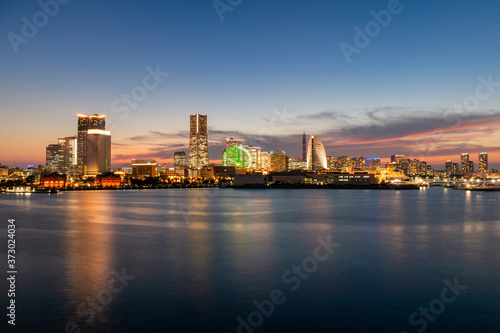 Minato Mirai skyline during the sunset with the reflection in the sea. Long exposure.